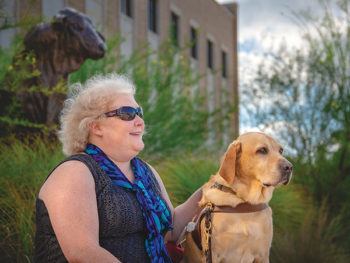 woman sitting next to guide dog