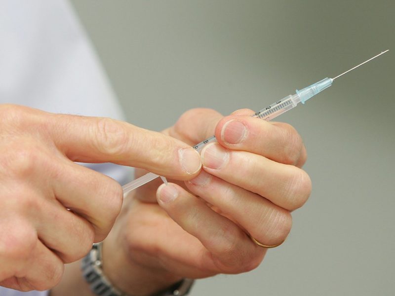 a photo of a man's hands holding a hypodermic needle