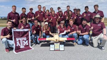 group shot of student gropu wearing maroon polo shirts with the airplane the designed