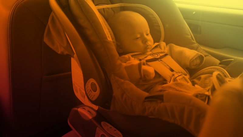 yellow and orange image of child sleeping in carseat