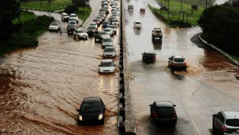 cars stand in traffic submerged in flooded roadway