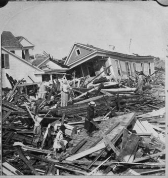 black and white historical photo of people looking through wreckage after a hurricane