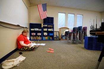 a photo of a teacher in an empty classroom