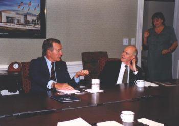 brent scowcroft sitting at a conference table listening to president bush speak