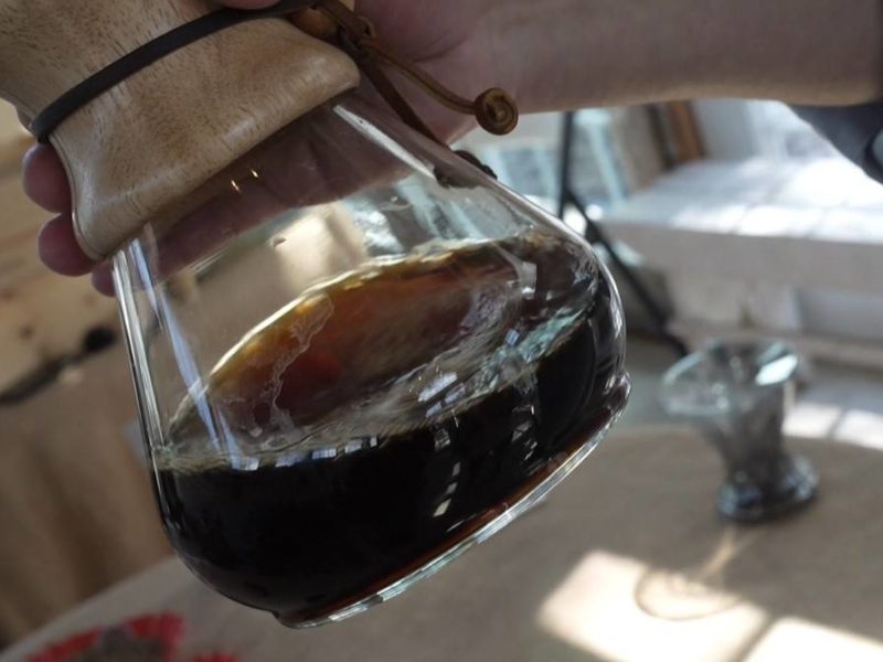 close up of hand swirling coffee inside a chemex