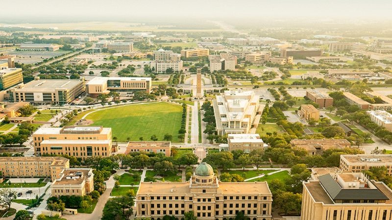 aerial view of campus with support aggieland graphic overlay