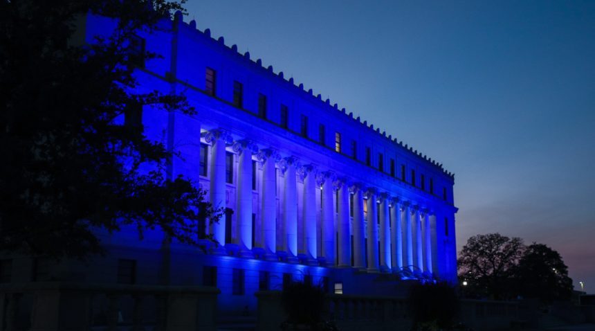blue light shining on the administration building exterior