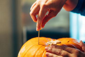Cropped Hand Of Person Carving Jack O Lantern