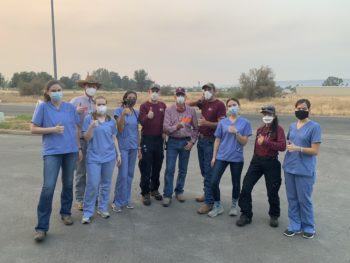 vet team stands outside wearing face masks