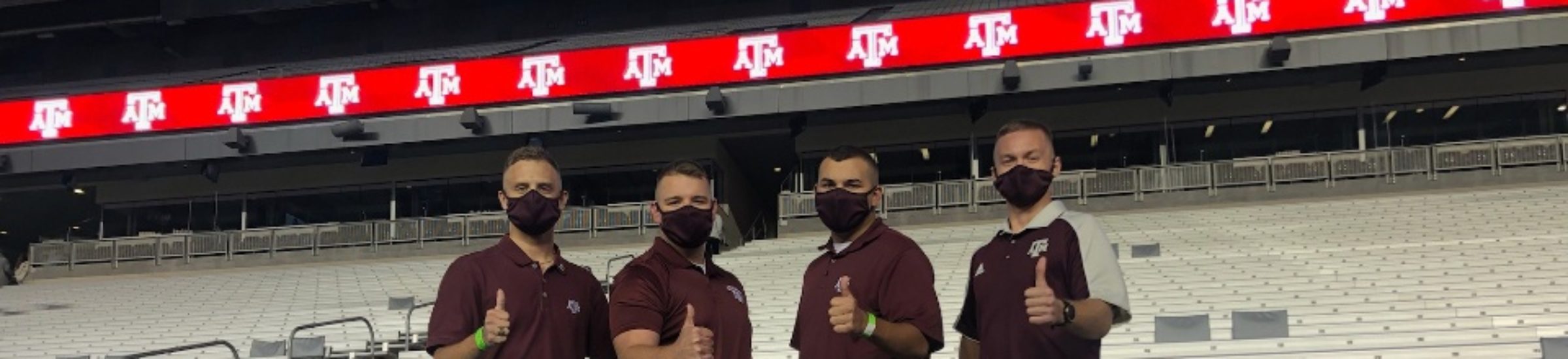 Texas A&M and Galveston Yell Leaders pose with thumbs up at Kyle Field after Midnight Yell on Oct. 30, 2020