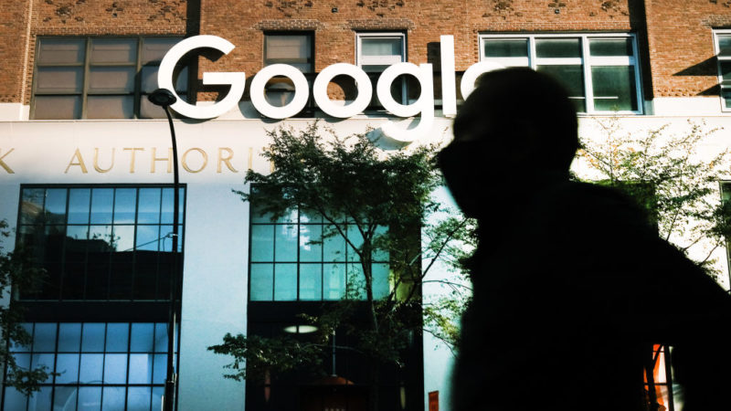 man in shadow walks by the office of google in new york city