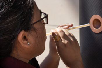 a student blows into a straw