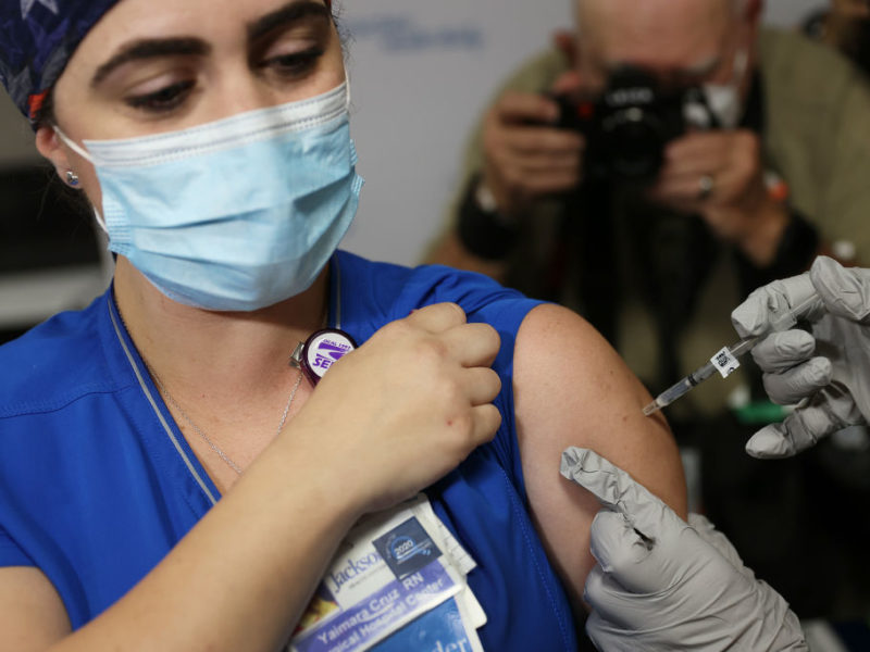 a nurse is photographed while receiving a vaccine