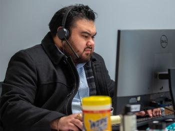 a photo of Oscar Hernandez, Jr. working on a computer at the COVID operations center