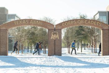 students walk through the snow at the Corps of Cadets arches