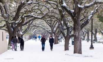 students walk through campus covered in snow