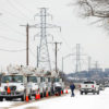 eletric service trucks lined up at power lines in snow
