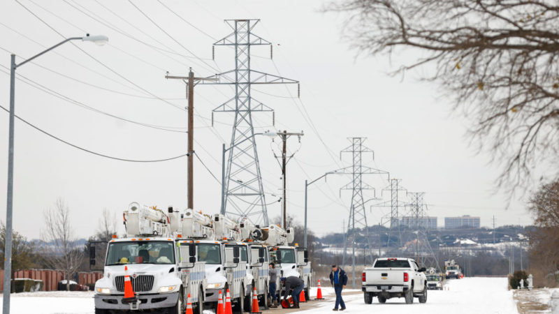 eletric service trucks lined up at power lines in snow