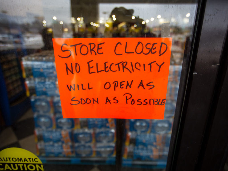 a sign on a window states that a store is closed due to no electricity