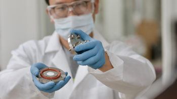close up of a researcher wearing lab equipment holding pieces of dehumidfier