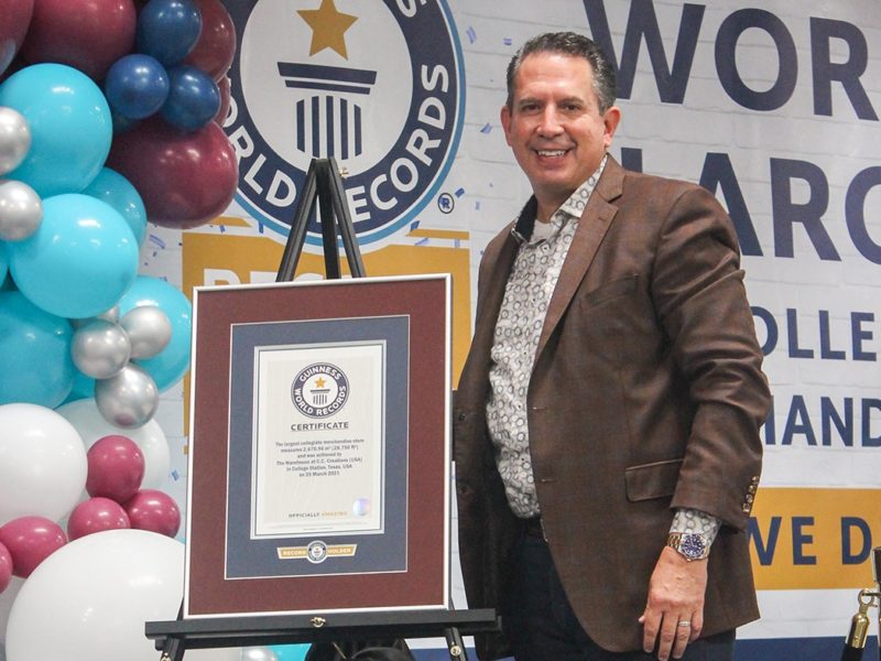 a photo of C.C. Creations owner Kenny Lawson posing with the store's world record certificate