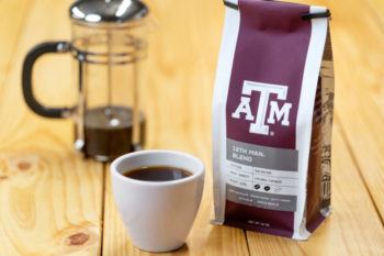 photo of a french press and coffee cup next to a bag of coffee with a&m logo