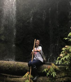 student sitting in front of a waterfall