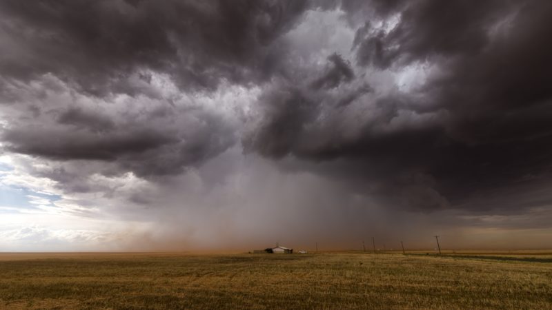 thunderstorm supercell over a lone house in a field