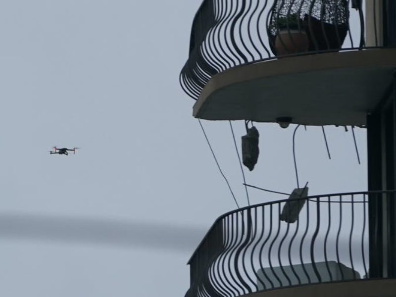 a drone flying next to balconies
