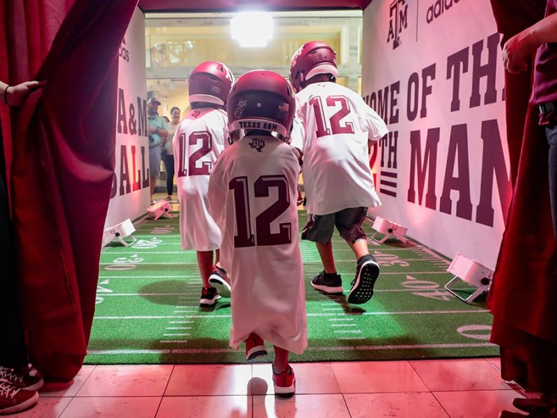 a photo of children in A&M jerseys running through a Texas A&M brand experience