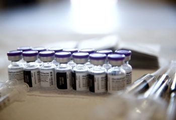 vials of the pfizer covid-19 vaccine set out on a table