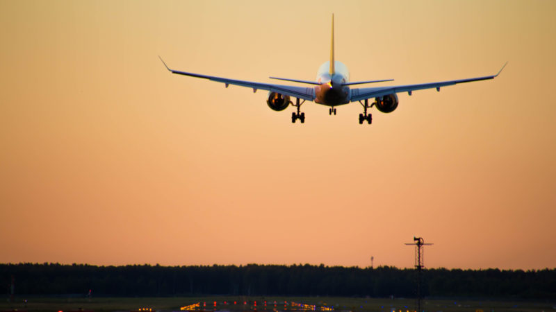 airplane approaching runway at sunset