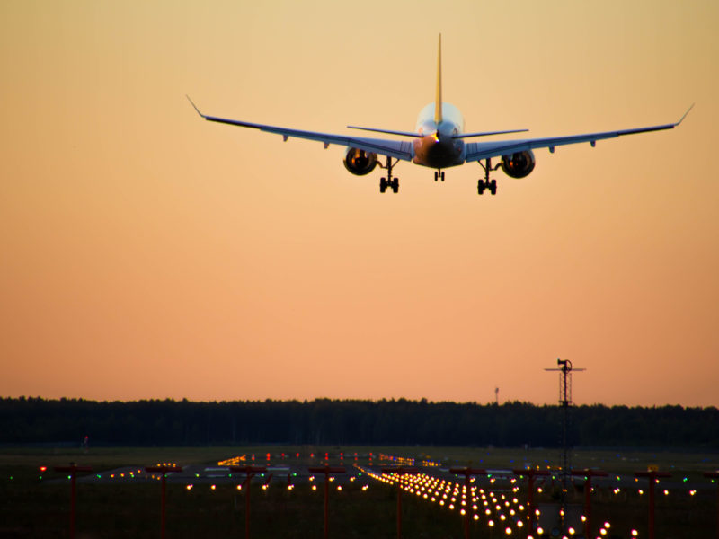 airplane approaching runway at sunset