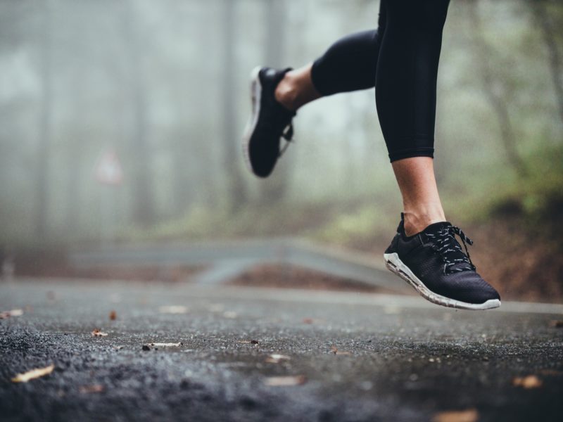 view of a woman's legs running on a road on a foggy day