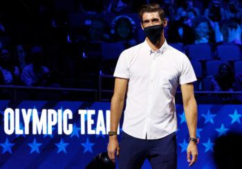 michael phelps wearing a face mask standing in front of a crowd
