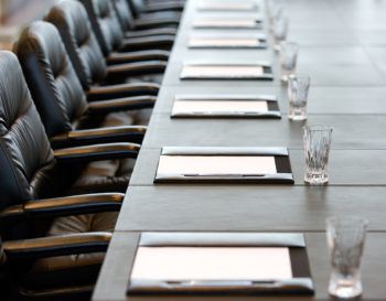 CLOSE UP OF A CONFERENCE ROOM TABLE SET UP FOR A MEETING