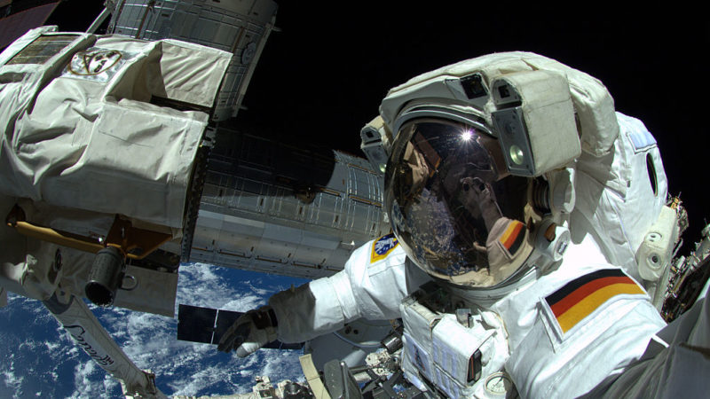 astronaut floating in space outside international space station