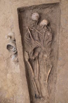 overhead view into a grave of two skeletons embracing