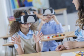 children in a classroom wearing virtual reality headsets