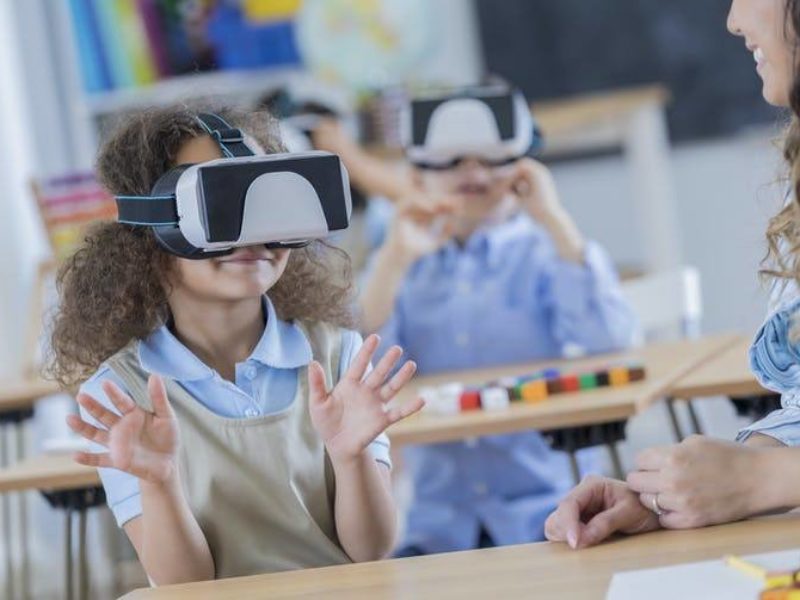 children in a classroom wearing virtual reality headsets