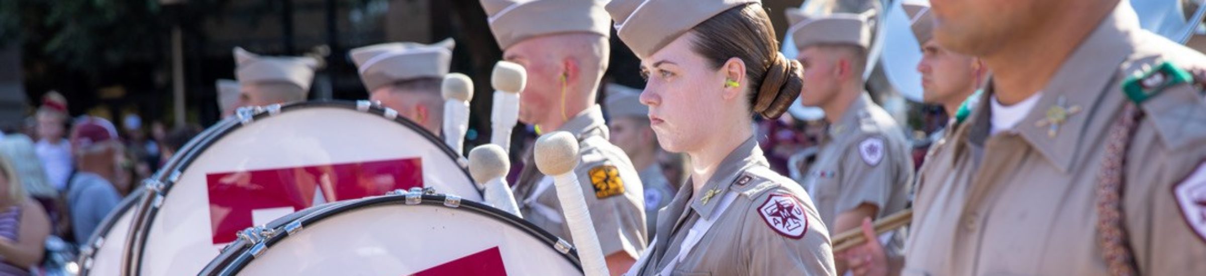 a photo of Amanda Lovitt standing with the Aggie band during Corps March-in