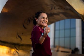 jennifer rodriguez giving a gig 'em in front of the aggie ring statue