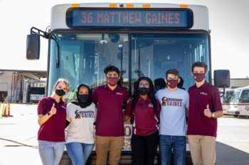 students pose in front of the campus bus on the Matthew Gaines route