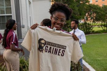 a student holding up an Everybody Gaines t-shirt