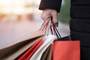 close up of woman holding several shopping bags in one hand
