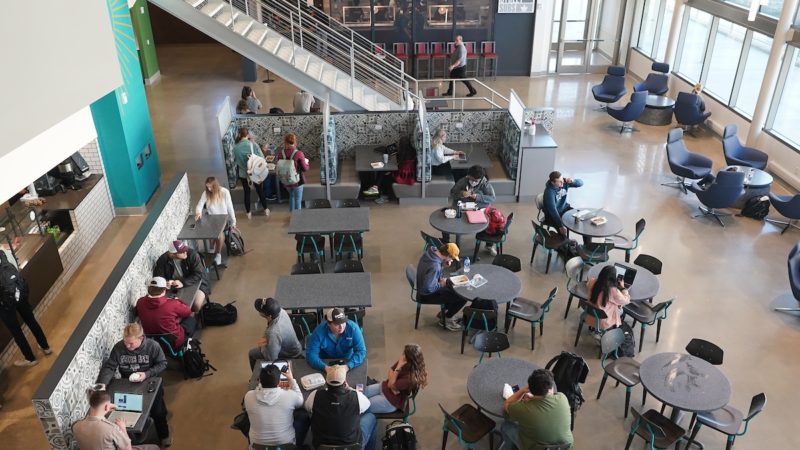 overhead view of students seated at round tables in a dining hall