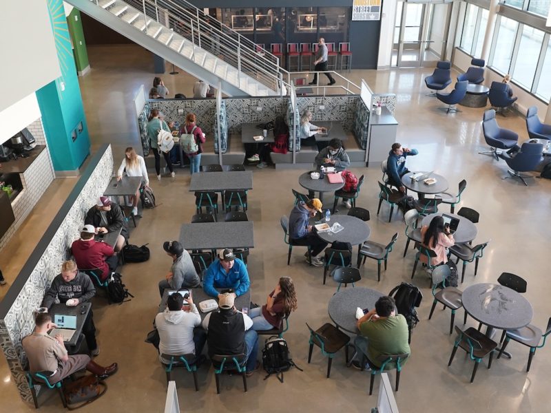 overhead view of students seated at round tables in a dining hall