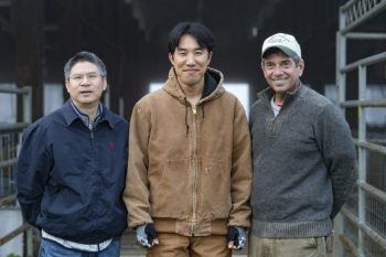 group photo of tree men outside barn