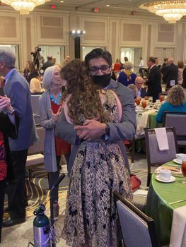 student hugging her doctor at a luncheon