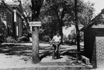 a boy in 1933 North Carolina drinking from a water fountain under a "colored" sign
